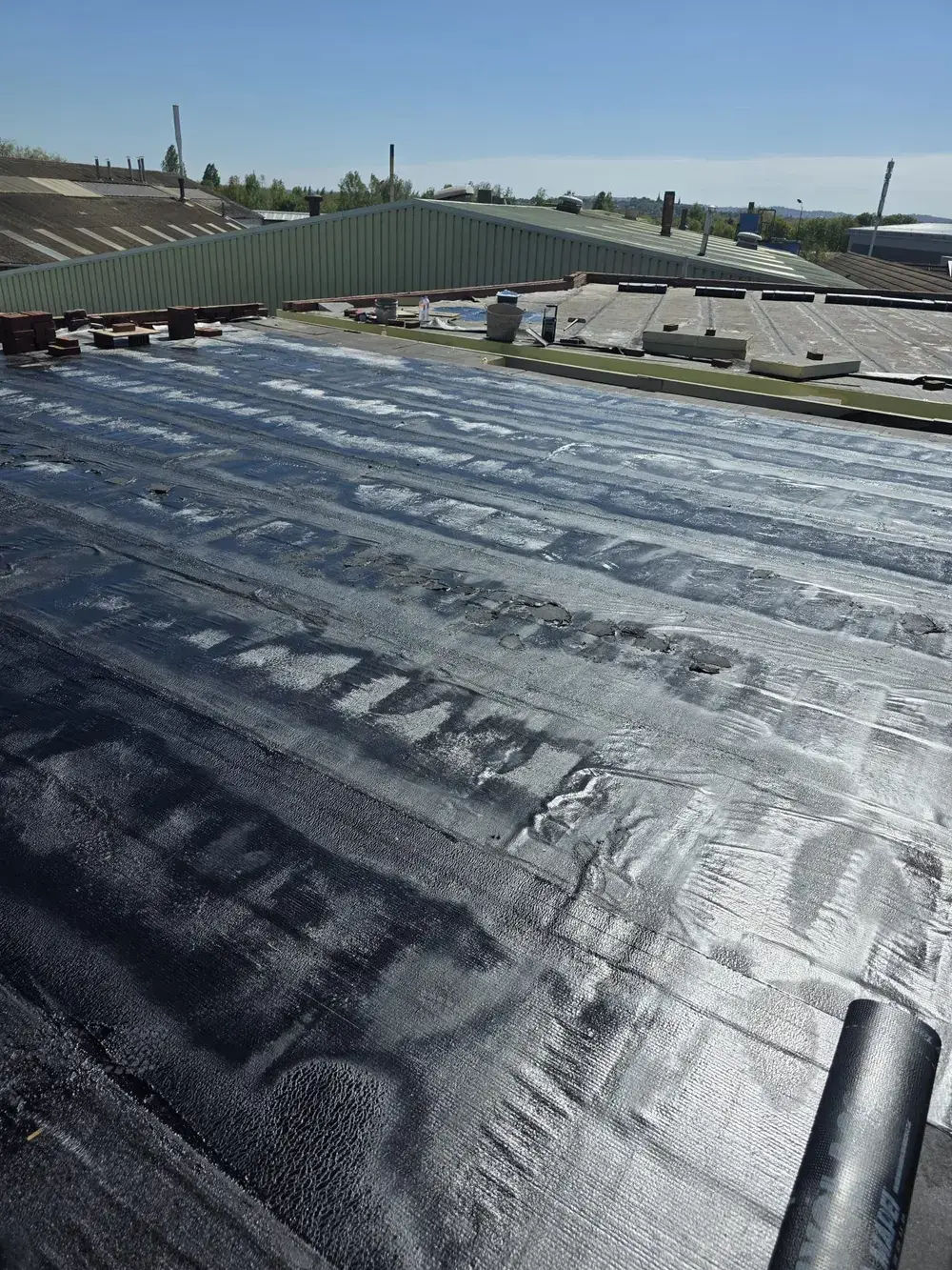 Roof coating applied to an industrial roof